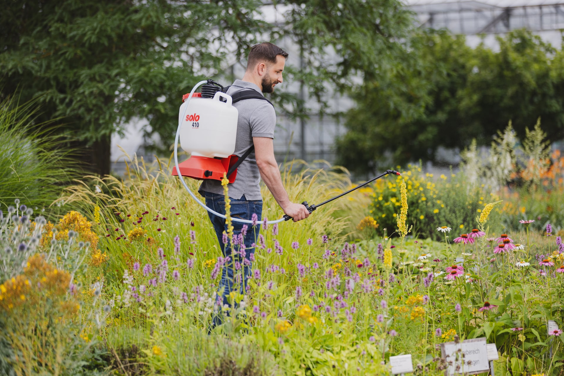 Privatanwender beim Sprühen mit der SOLO Rückenspritze 410 im bunten Garten – ideal für Pflanzenschutz und Pflege im Hausgarten.